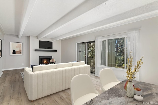 living room featuring light wood-type flooring and beamed ceiling