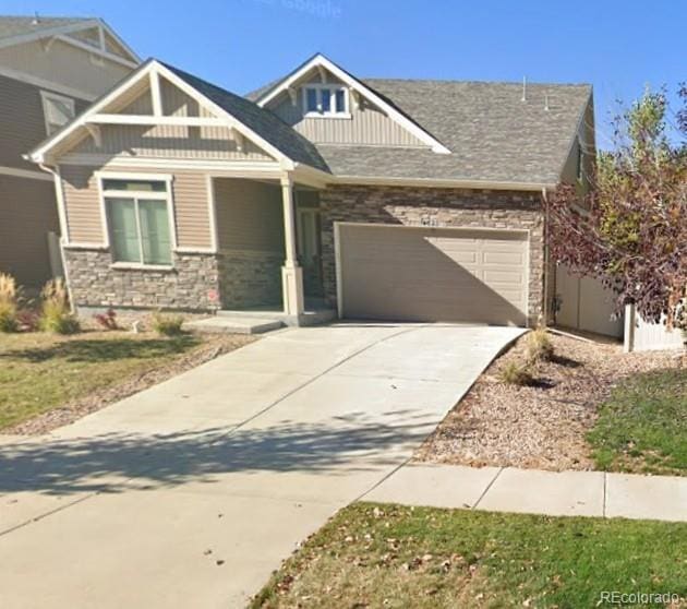 craftsman-style home featuring stone siding, an attached garage, concrete driveway, and board and batten siding