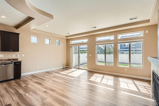 4625 Walden Ct, Denver, CO 80249 - unfurnished living room featuring light wood-type flooring, a raised ceiling, baseboards, a fireplace with flush hearth, and recessed lighting