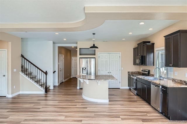 4625 Walden Ct, Denver, CO 80249 - kitchen with stainless steel appliances, a sink, a center island, a kitchen breakfast bar, and light wood finished floors