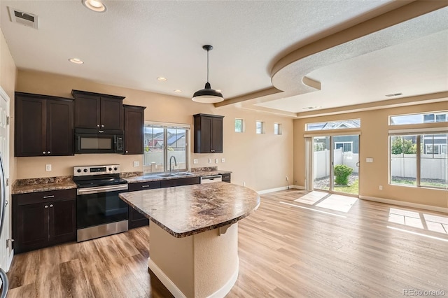 4625 Walden Ct, Denver, CO 80249 - kitchen with stainless steel electric range, black microwave, a sink, light wood-style floors, and a kitchen island