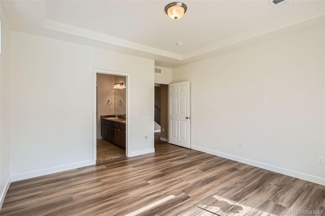 4625 Walden Ct, Denver, CO 80249 - unfurnished bedroom with wood finished floors, a raised ceiling, and a sink