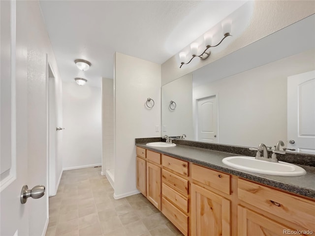 8612 13th St, Greeley, CO 80634 - bathroom featuring walk in shower, baseboards, a sink, and double vanity