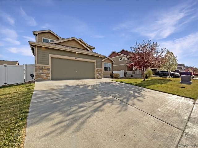 8612 13th St, Greeley, CO 80634 - craftsman house featuring fence, a front lawn, concrete driveway, stone siding, and a garage
