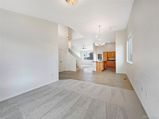 8612 13th St, Greeley, CO 80634 - unfurnished living room featuring light carpet, baseboards, a chandelier, and stairway
