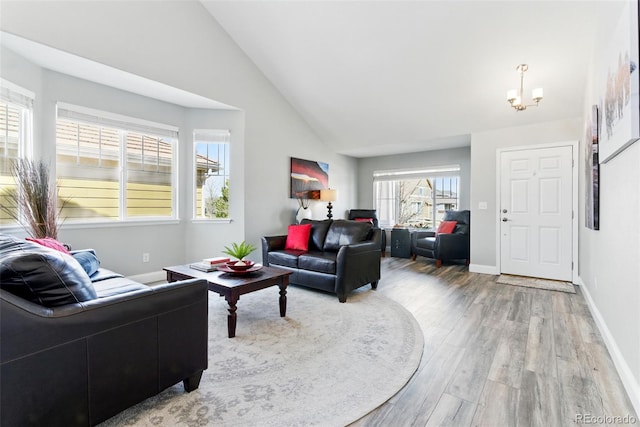 living area featuring baseboards, an inviting chandelier, light wood-style flooring, and vaulted ceiling