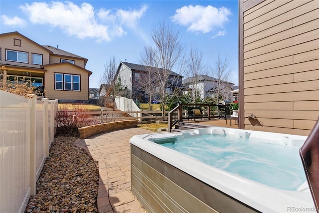 view of patio featuring a deck, a hot tub, and a fenced backyard