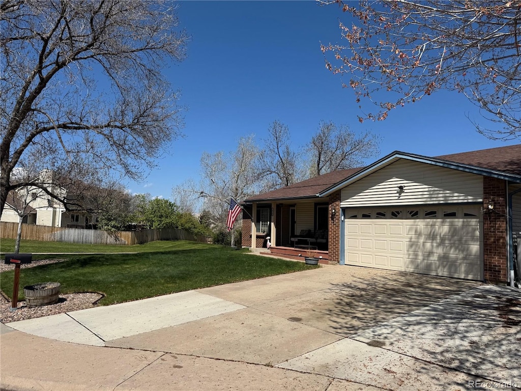 view of front facade featuring a garage, fence, a front lawn, brick siding, and driveway