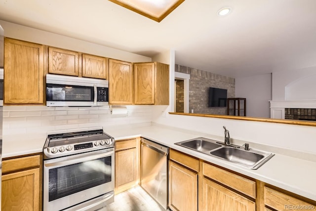 kitchen featuring sink, decorative backsplash, light wood-type flooring, and appliances with stainless steel finishes