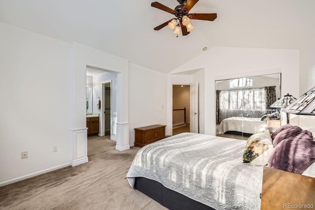 carpeted bedroom with ceiling fan, ensuite bathroom, and vaulted ceiling