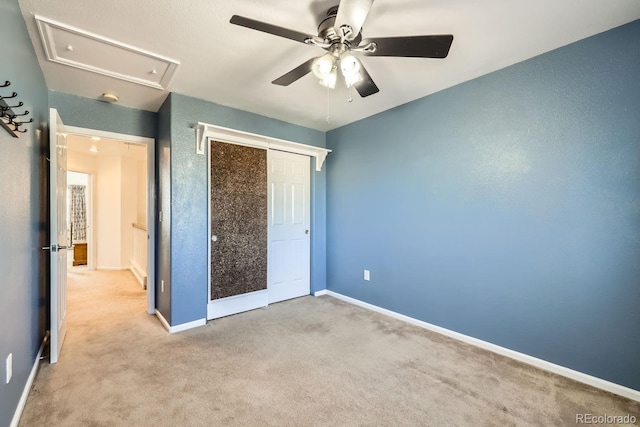 unfurnished bedroom featuring ceiling fan, a closet, and light carpet