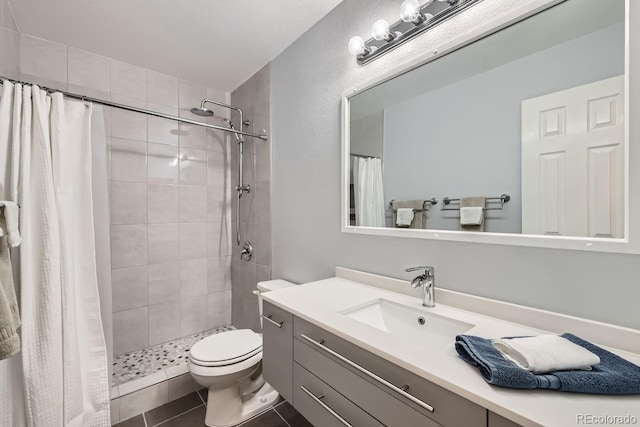 bathroom featuring vanity, curtained shower, tile patterned floors, and toilet