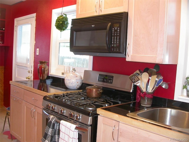 5618 Carr St, Arvada, CO 80002 - kitchen featuring stainless steel range with gas stovetop, black microwave, a sink, and dark countertops