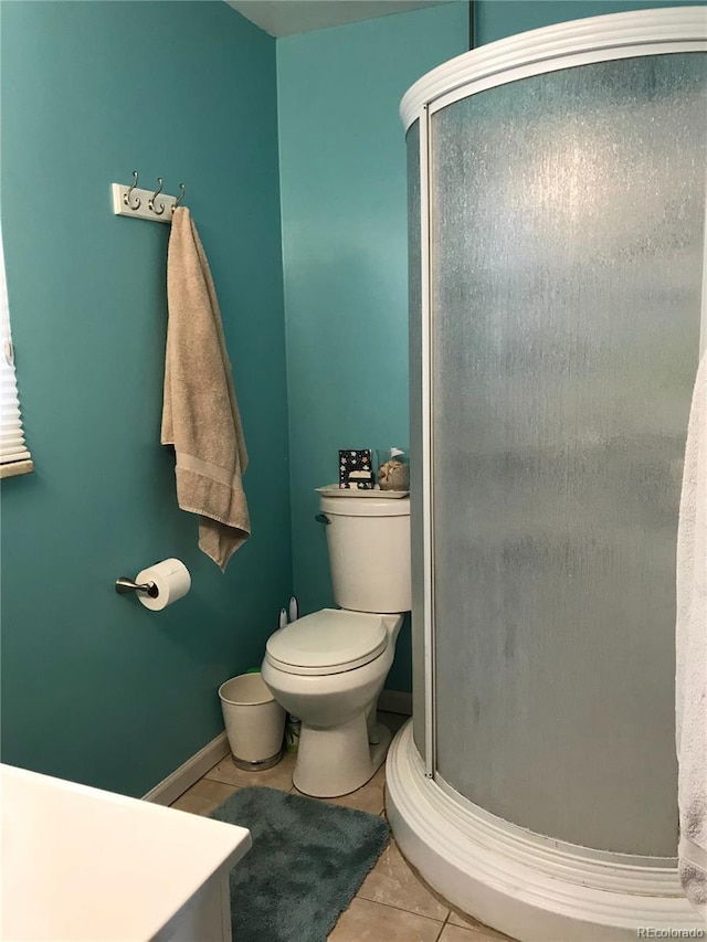 5618 Carr St, Arvada, CO 80002 - full bathroom with tile patterned flooring, a stall shower, toilet, and baseboards