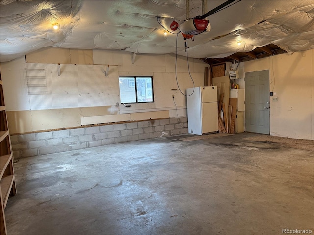 5618 Carr St, Arvada, CO 80002 - garage with freestanding refrigerator, a garage door opener, and concrete block wall