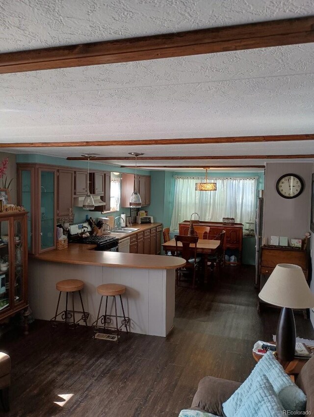 510 N 19th St Unit 19A, Canon City, CO 81212 - kitchen with black gas range, dark wood-type flooring, a peninsula, freestanding refrigerator, and a sink