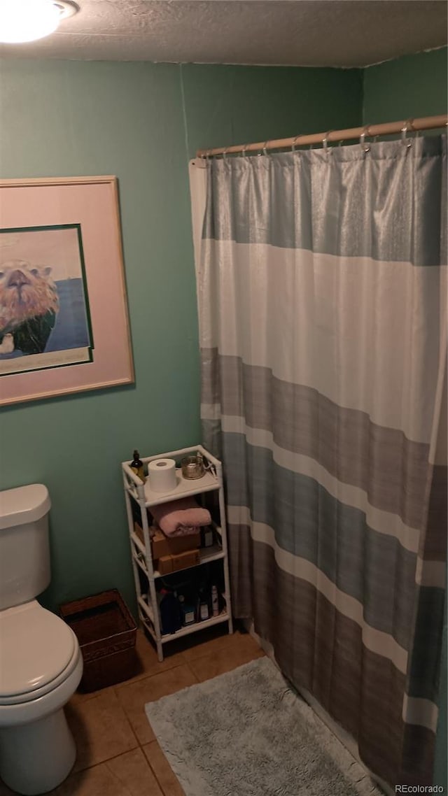 510 N 19th St Unit 19A, Canon City, CO 81212 - bathroom featuring tile patterned floors, toilet, a textured ceiling, and a shower with shower curtain