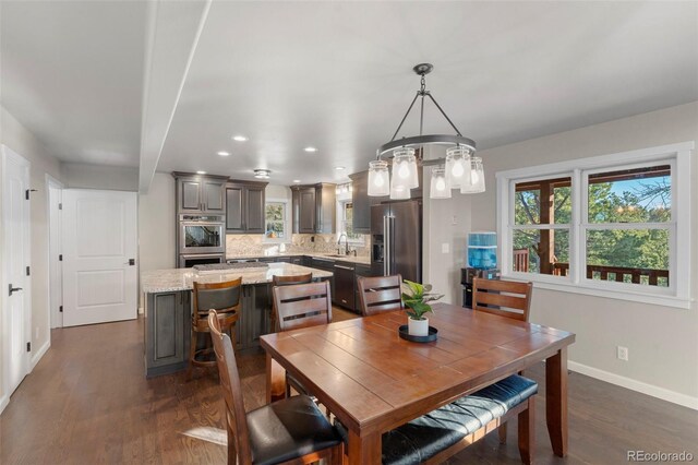 dining room featuring dark hardwood / wood-style flooring, a notable chandelier, and sink