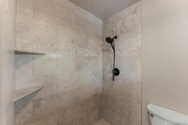 bathroom with toilet and a tile shower