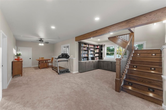 workout area featuring ceiling fan and light colored carpet