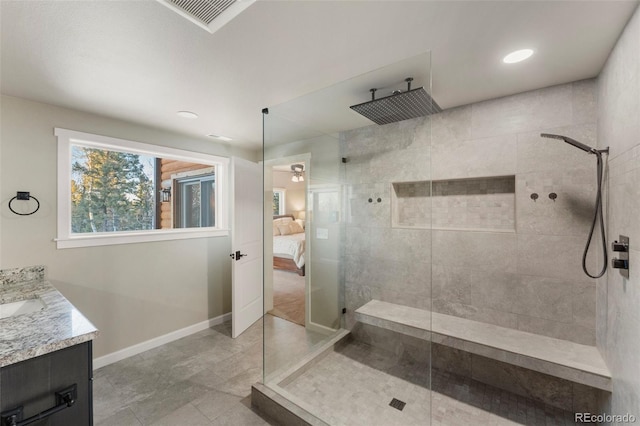 bathroom featuring a tile shower, ceiling fan, tile patterned flooring, and vanity