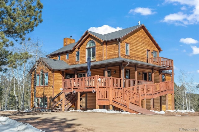 log home featuring a chimney and stairway