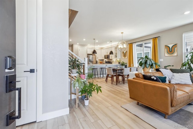 living area featuring light wood-type flooring and recessed lighting