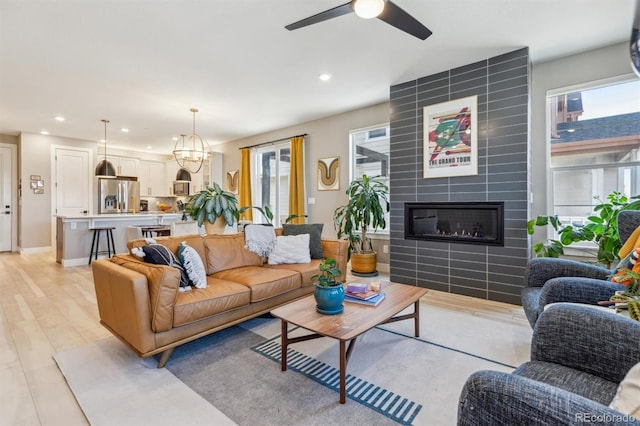 living area featuring a healthy amount of sunlight, a tiled fireplace, and recessed lighting