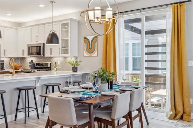 dining room with recessed lighting, a notable chandelier, and light wood-style floors