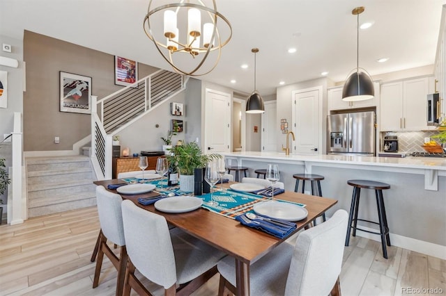 dining space featuring recessed lighting, stairway, a chandelier, and light wood-style floors