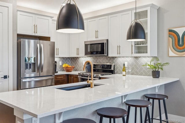 kitchen with glass insert cabinets, backsplash, a breakfast bar, and stainless steel appliances