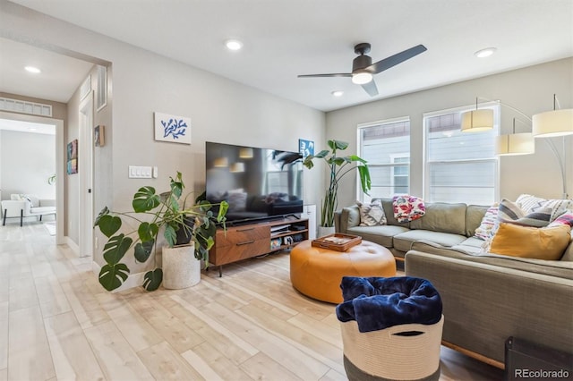 living room with light wood-type flooring, a ceiling fan, and recessed lighting