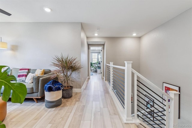 corridor featuring recessed lighting, an upstairs landing, and light wood-style flooring