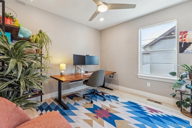 home office with visible vents, ceiling fan, wood finished floors, and baseboards