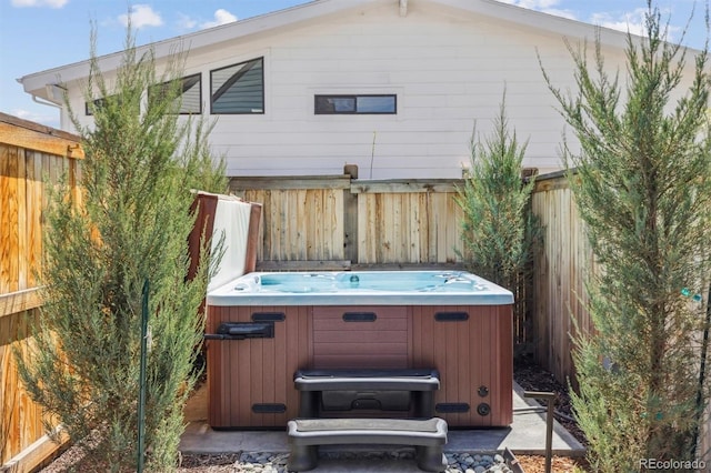 exterior space featuring fence and a hot tub
