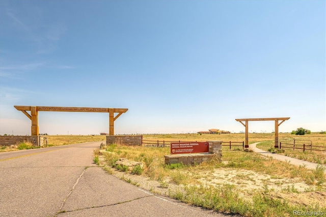 view of community with fence and a rural view