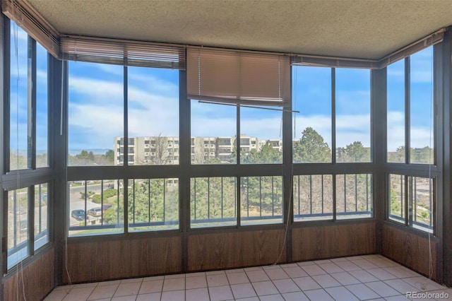 unfurnished sunroom featuring a textured ceiling and tile patterned flooring