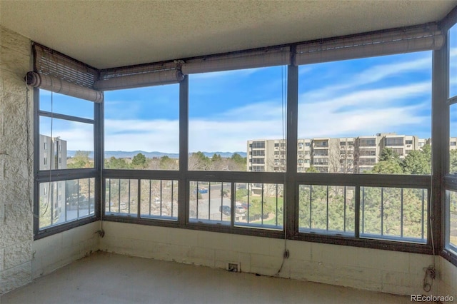 unfurnished sunroom featuring concrete flooring and a textured ceiling