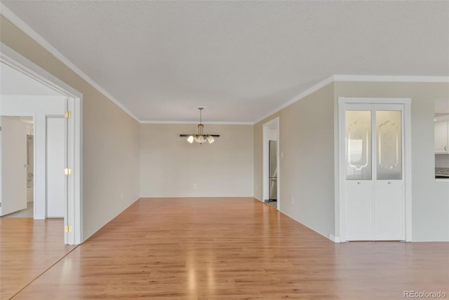 unfurnished dining area with a chandelier, wood finished floors, and crown molding
