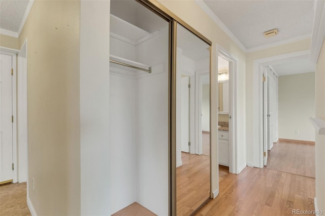 hall featuring crown molding and light wood finished floors