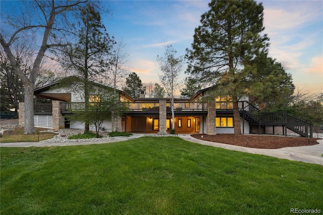 view of front of home with a lawn, stone siding, stairway, and a deck