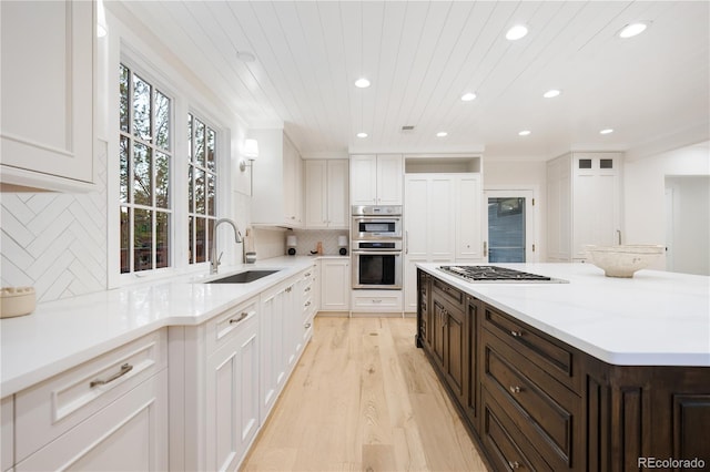 kitchen featuring recessed lighting, stainless steel appliances, white cabinets, and a sink