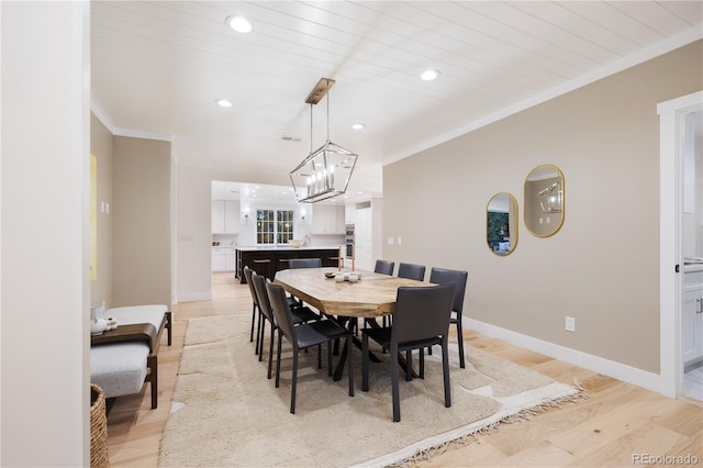 dining area featuring light wood-style flooring, recessed lighting, baseboards, a chandelier, and crown molding