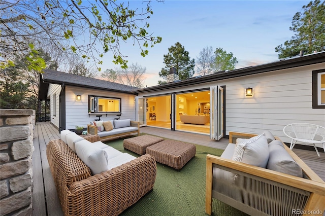 back of property at dusk with an outdoor living space and a wooden deck