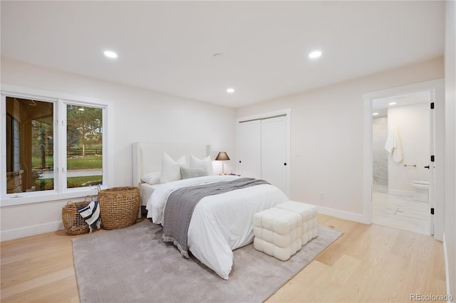 bedroom with a closet, light wood-style floors, connected bathroom, and recessed lighting