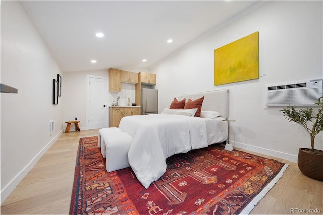 bedroom featuring freestanding refrigerator, an AC wall unit, light wood-style floors, lofted ceiling, and recessed lighting