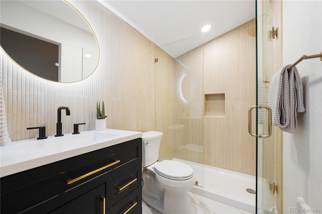 bathroom featuring toilet, tile walls, vanity, and a shower stall