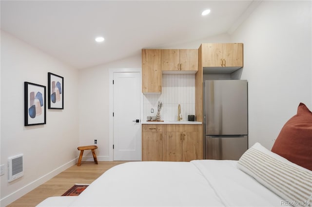 bedroom featuring freestanding refrigerator, light wood finished floors, lofted ceiling, and recessed lighting