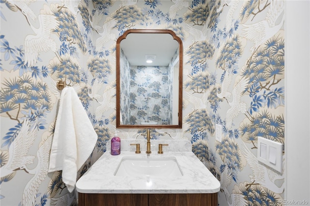 bathroom with wallpapered walls and vanity