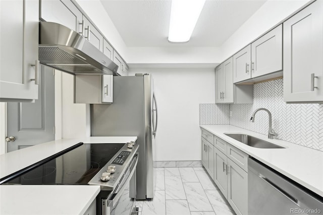 kitchen featuring tasteful backsplash, stainless steel appliances, sink, and a textured ceiling